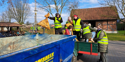 Dorsäuberungsaktion Müll wird in Container geworfen